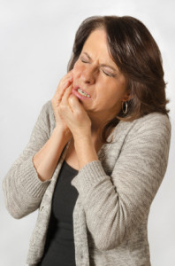 Woman with a toothache or dental emergency needing either a root canal or extraction