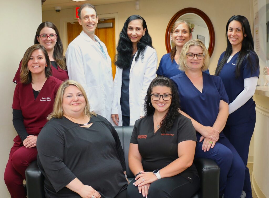 Orange, CT dental office team photo showing dentists Drs. Nick and Carla Calcaterra