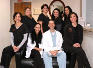 Orange, CT dental office team photo showing dentists Drs. Nick and Carla Calcaterra